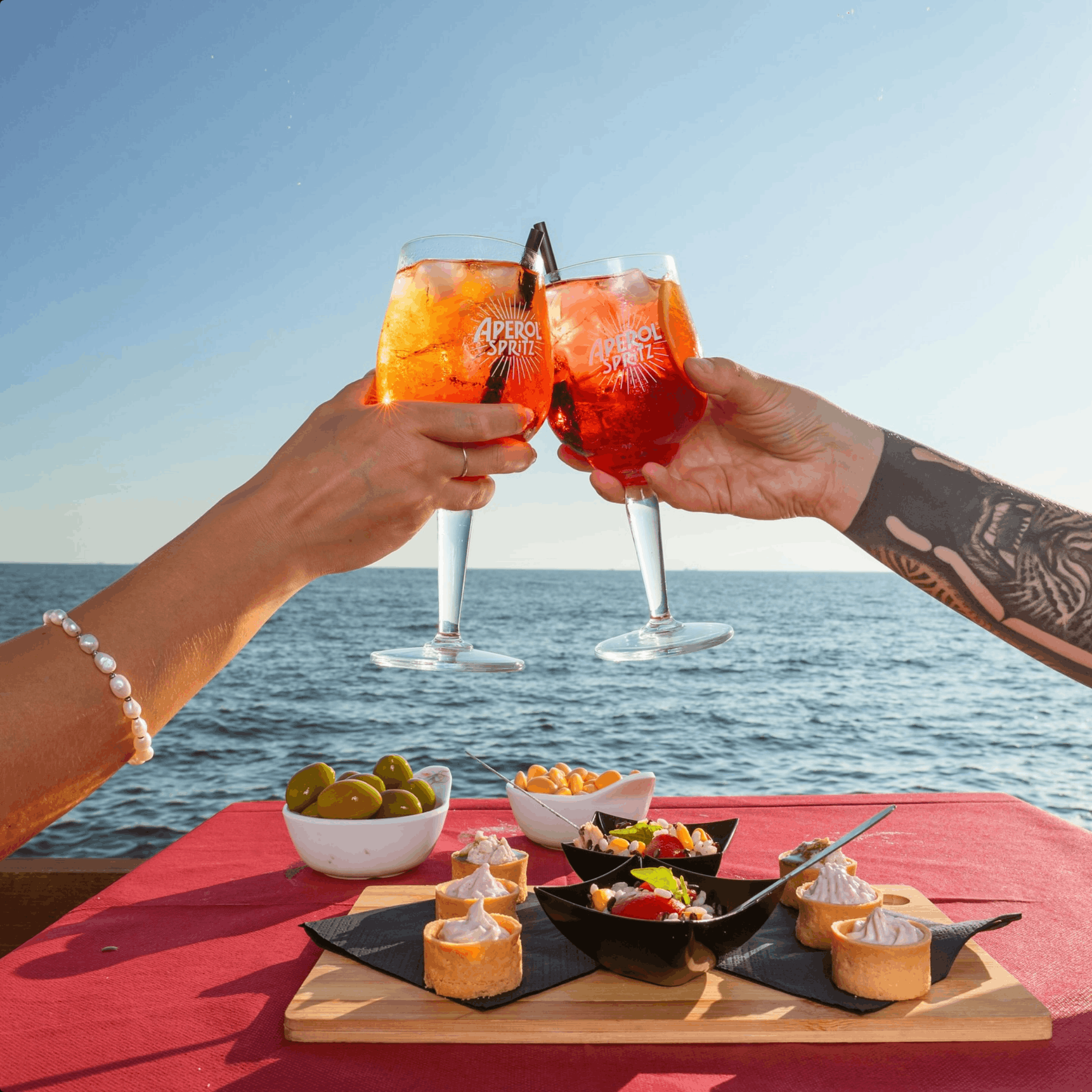 Aperol Spritz al tramonto sul deck del Noa Beach